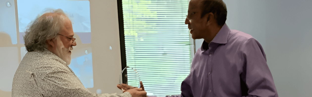 Ashok Mathur shaking hands with employee of 10 years