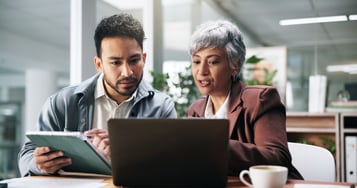  Two professionals considering EHRs on Laptop and Tablet