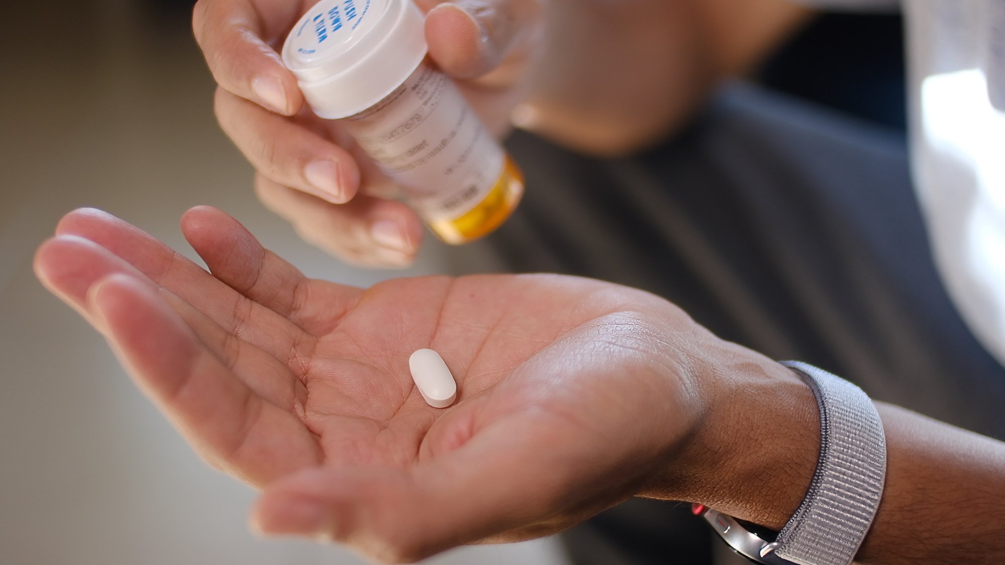 Hand holding a medication for MAT