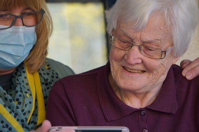 Nurse looking at tablet with smiling patient