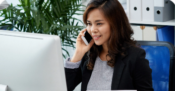 asian-business-lady-sitting-office-holding-document-talking-mobile-phone