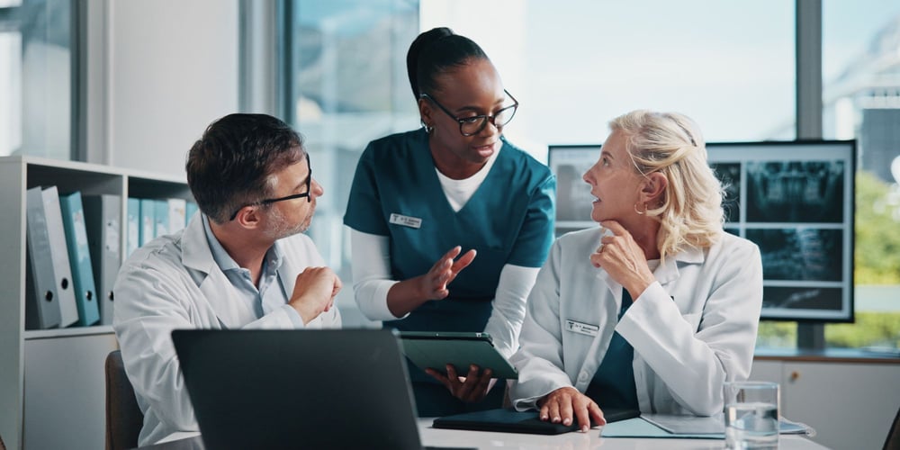 Two doctors and a nurse on a laptop
